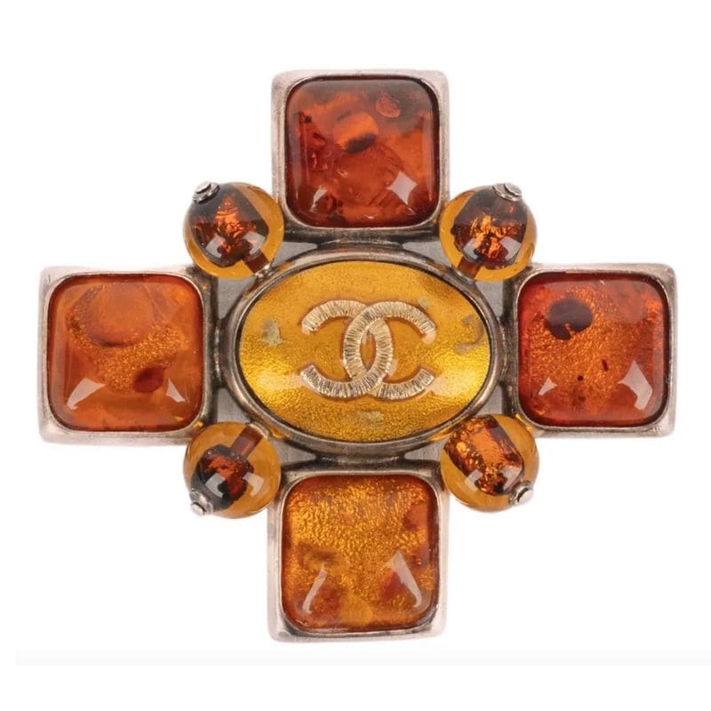 Spilla gioiello: come indossarla e dove trovare le più belle, dal vintage al contemporaneo 4 Spilla gioiello a croce in metallo dorato con cabochon ocra, parte della collezione Autunno-Inverno 2007 di Chanel, direzione artistica Karl Lagerfeld.