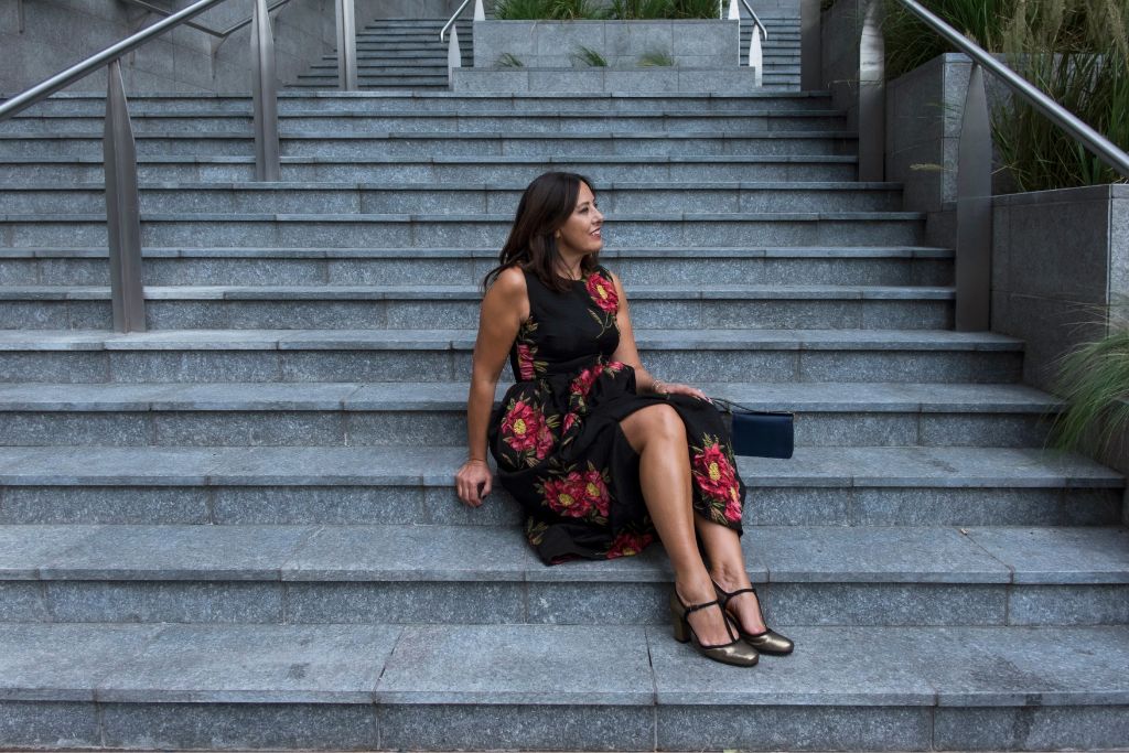 donna seduta sulle scale con abito a fiori
