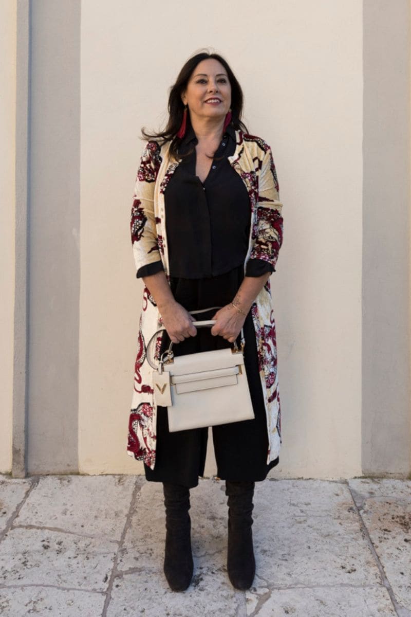 bermuda donna invernali:donna che indossa bermuda neri con stivali di camoscio e borsa bianca