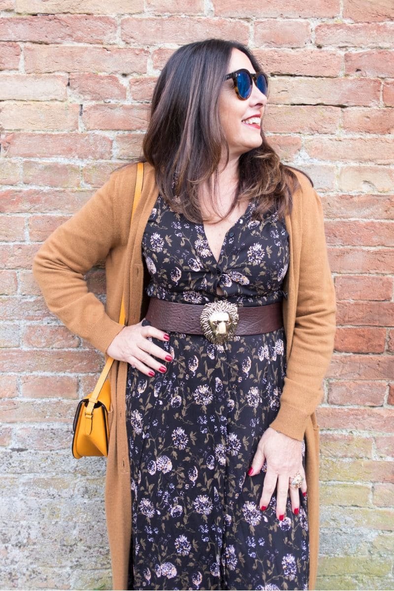 Donna over 60 con abito fantasia marrone e cardigan cammello, look femminile e attuale