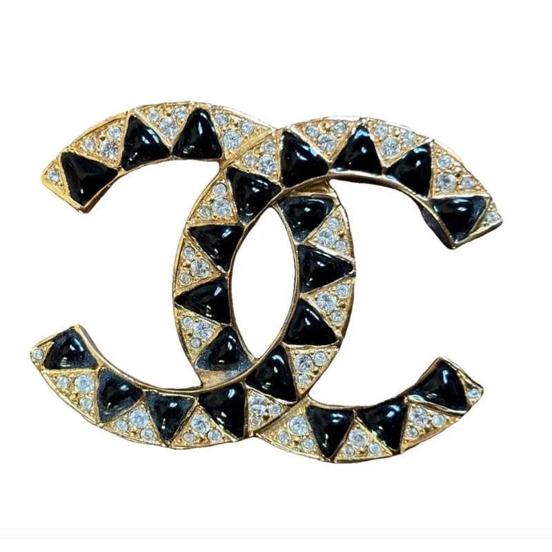 Spilla gioiello: come indossarla e dove trovare le più belle, dal vintage al contemporaneo 3 Spilla gioiello in metallo dorato con cristalli e smalti neri, parte della collezione Métiers d’Art Chanel, selezionata nella wishlist su Vestiaire Collective.
