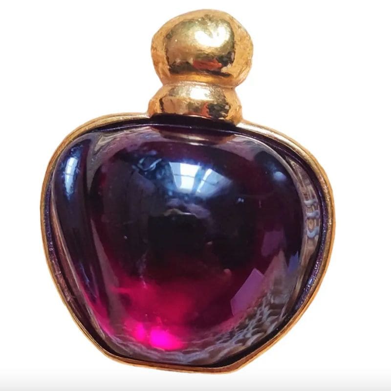Spilla gioiello: come indossarla e dove trovare le più belle, dal vintage al contemporaneo 5 Spilla gioiello “Poison” di Christian Dior in metallo dorato con cabochon bordeaux, ispirata all’iconico flacone del profumo.